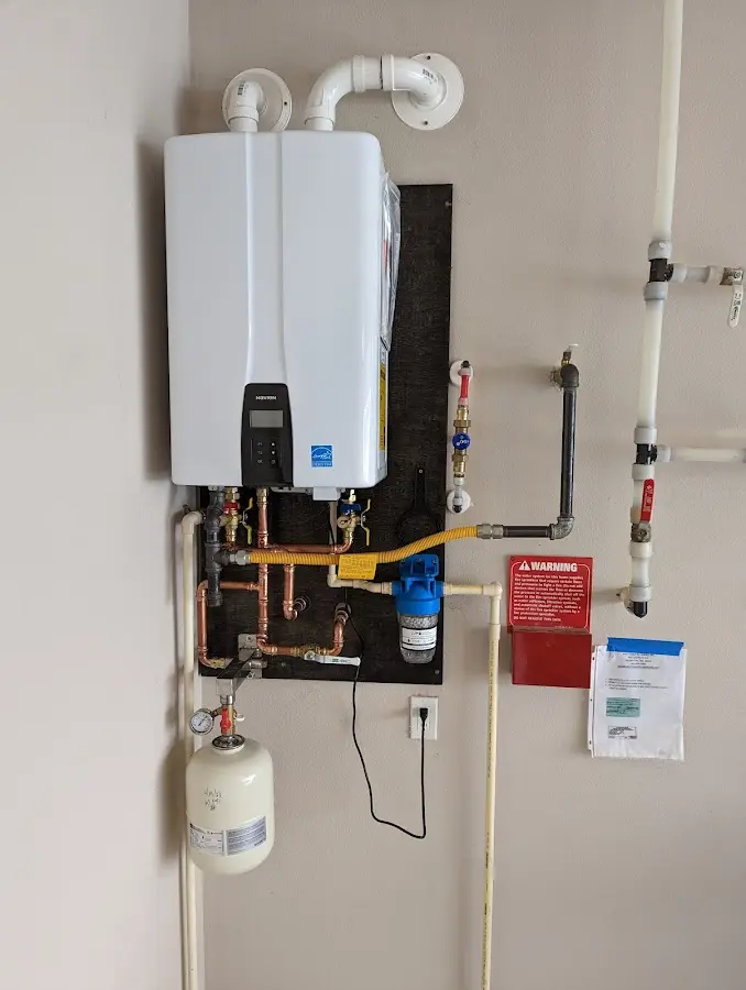 Professional plumber installing copper piping in a Caro home